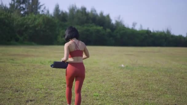 手持ちのアジア系中国人女性のヨギ拡散マット朝の太陽 — ストック動画