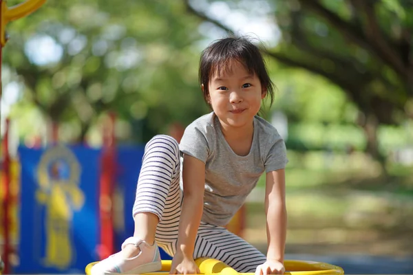 笑顔アジアの中国人の女の子で遊び場の障害物の上 — ストック写真