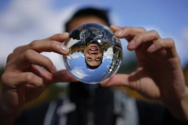 Engraçado imagem de asiático homem através de uma bola de cristal — Fotografia de Stock