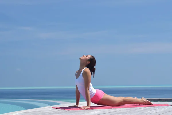 Mujer china asiática practicando yoga junto al mar — Foto de Stock