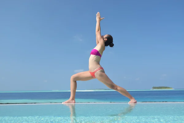 Asiatisk kinesisk kvinna utövar yoga vid havet — Stockfoto