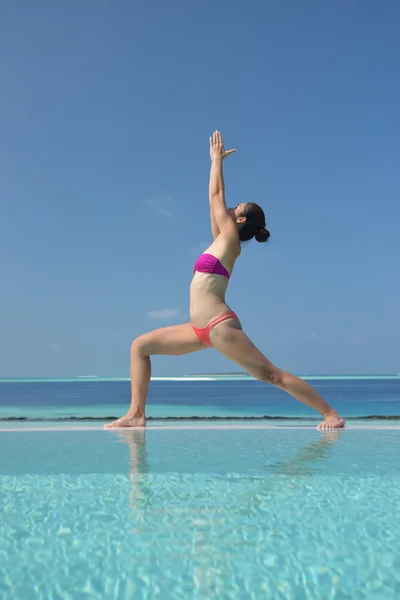 Asiatisk kinesisk kvinna utövar yoga vid havet — Stockfoto
