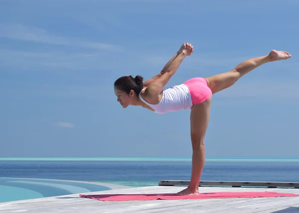 Asiatisk kinesisk kvinna utövar yoga vid havet — Stockfoto