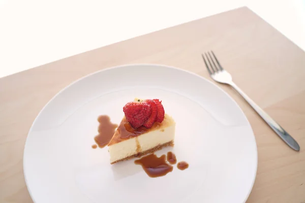 Pequeña rebanada de pastel de queso en un plato grande —  Fotos de Stock