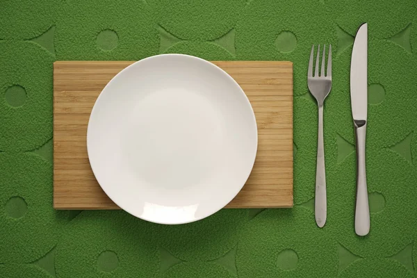 Moderni ruokailuvälineet asetettu vihreä kangas tausta — kuvapankkivalokuva