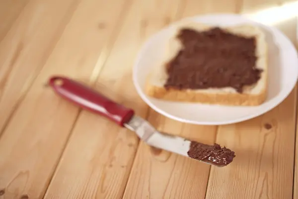 Spreading delicious peanut butter on white bread — Stock Photo, Image