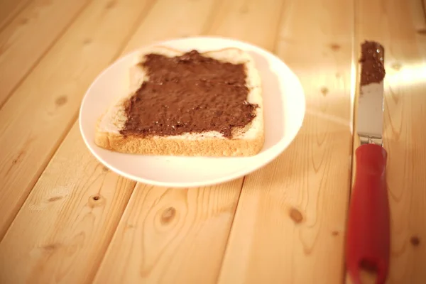 Spreading delicious peanut butter on white bread — Stock Photo, Image