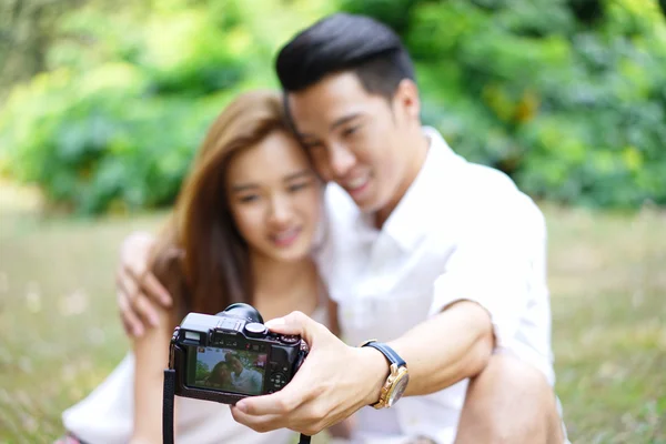 Happy dating couple outdoor picnic with camera — Stock Photo, Image