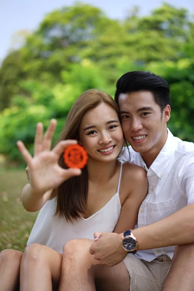 Happy asian couple in love holding symbol — Stock Photo, Image