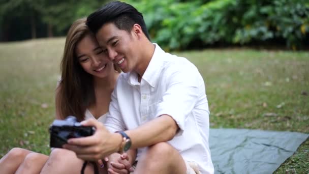 Asiático pareja al aire libre picnic tomando su propio selfies — Vídeos de Stock