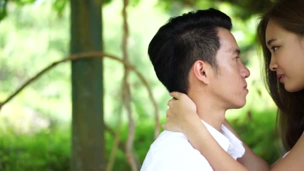 Asian couple sitting intimately in a park — Stock Video