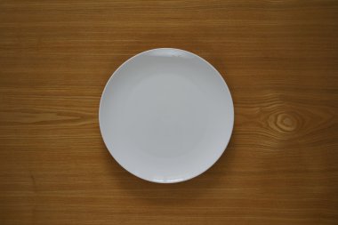 Bir ahşap masa üstü boş porselen tabakta