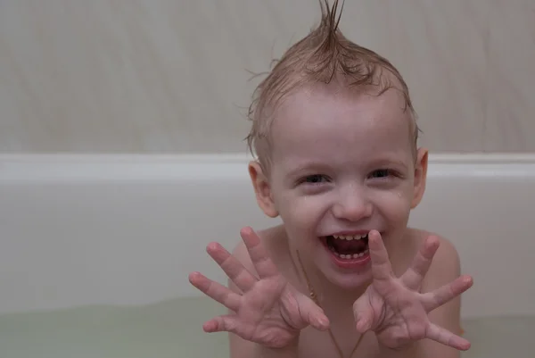 The happy boy is showing the Godzilla in a bathroom — Stock Photo, Image