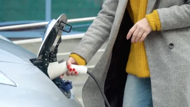 Mujeres manos enchufando su coche eléctrico para cargar. Recarga de coches eléctricos — Vídeo de stock