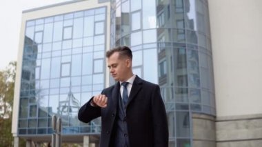 Mavi ceketli ve ofisin yakınında iş görüşmesini bekleyen zarif genç bir erkek işadamı.