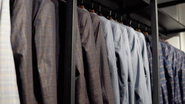 Lüks erkek kıyafetleri mağazasındaki yeni koleksiyondan ceketlerle dolu bir vitrin. Erkek giyim mağazası — Stok video