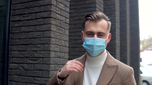 Snygg affärsman tar av den medicinska masken på gatan nära ett modernt kontor — Stockvideo