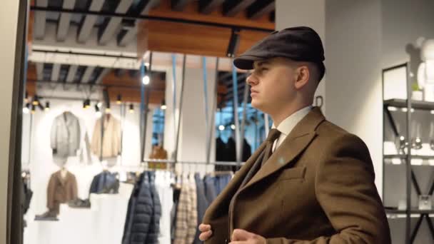 Mladý sebevědomý muž v luxusním pánském butiku zkouší nový oblek. Pánské oblečení obchod — Stock video
