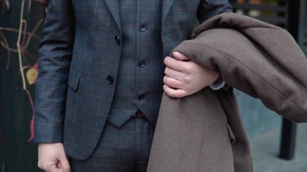 Close-up of stylish male businessman in brown suit and coat on wooden background — Stock Video