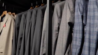 Lüks erkek kıyafetleri mağazasındaki yeni koleksiyondan ceketlerle dolu bir vitrin. Erkek giyim mağazası