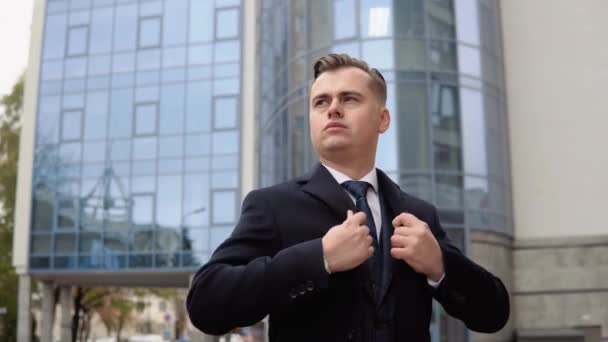 Elegante uomo d'affari in giacca blu e cappotto vicino al centro ufficio in attesa di riunioni di lavoro — Video Stock