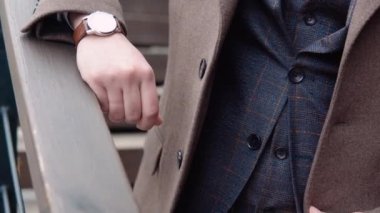 Kahverengi paltolu ve şapkalı şık işadamlarının yakın plan fotoğrafları.