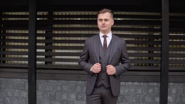 Snygg elegant manlig affärsman i brun kostym på trä bakgrund — Stockvideo