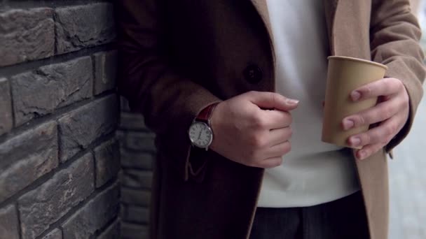 Красивий бізнесмен у коричневому пальто з кавою біля офісу. Крупним планом — стокове відео
