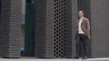 Takım elbiseli bir işadamı iş merkezinden geçiyor. Yavaş çekim