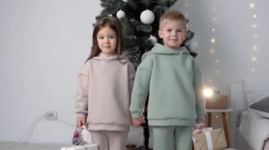 Erkek ve kız, Noel ağacının gront 'unda ince kalırlar.