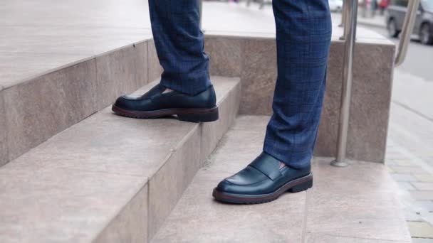 Um homem caminha pela rua com sapatos novos. Close-up de um homem pés. Movimento lento — Vídeo de Stock