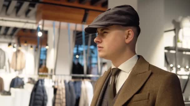 Jonge zelfverzekerde man in luxe herenkleding boetiek op zoek naar een nieuw pak. Kleding voor heren winkel — Stockvideo