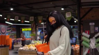 Genç siyahi kadın markette alışveriş yapıyor.
