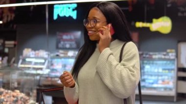 Süpermarkette telefonla konuşan bir kız.