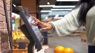 Maskeli kız süpermarketteki raflardan ürünleri seçiyor.