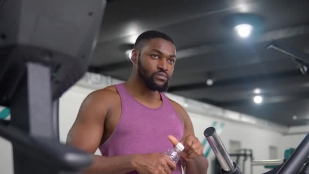 Uomo afroamericano che beve acqua dopo l'allenamento in palestra — Video Stock
