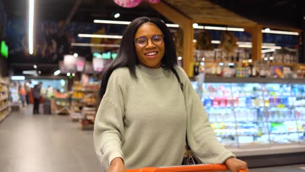 スーパーで買い物をしながら笑顔の女の子。ショッピングのコンセプト — ストック動画