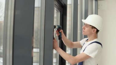 Sihirbaz bir tornavida ile pencere çerçevesine vidalar yükler