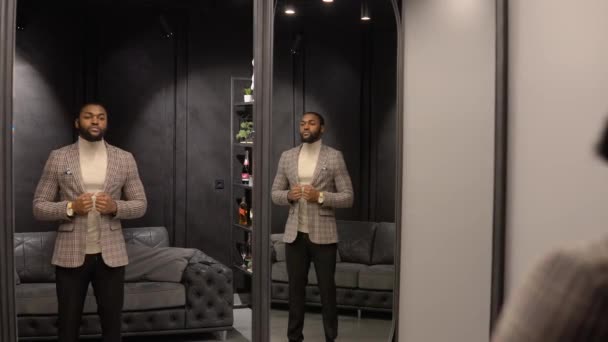 Young confident african american man in luxury menswear boutique choosing new suit. Mens clothing store — Stock Video