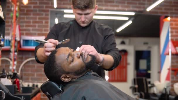 理发师用剪子剪下顾客的胡子.理发店里的人理发师的职业. — 图库视频影像