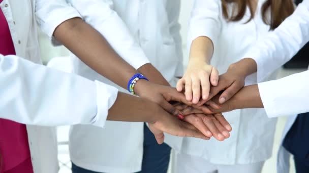 Ein Ärzteteam, dem Frauen und Männer unterschiedlicher Nationalitäten angehören, macht eine Geste der Einheit. Nahaufnahmen von Händen — Stockvideo