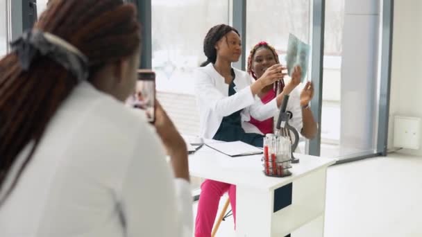 Amerikanische Ärztinnen werden am Telefon fotografiert — Stockvideo