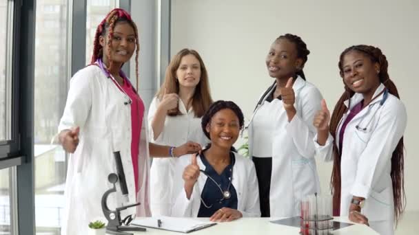 テーブルショーのクラスに座って立っている若い医療のグループ — ストック動画