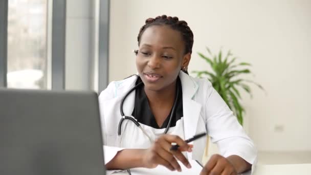 Afrikanische Ärztin mit Headset-Chat oder Konsultation auf Laptop — Stockvideo