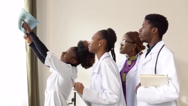 A group of four african american students discuss an x-ray — Stock Video