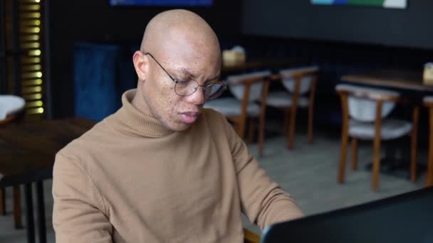 Yüzünde çiller olan Afrikalı Amerikalı bir adam dizüstü bilgisayarda klavyeyle mesaj atıyor. Ellerin yakın görüntüsü — Stok video