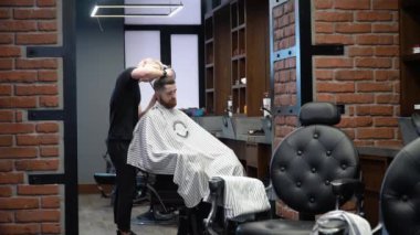 Şık bir berber dükkanında erkek saç kesimi süreci. Siyah ve terracotta vahşi bir iç mekan.