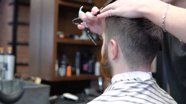 Corte de cabelo curto em uma barbearia. Close-up. Caucasiano jovem cliente e barbeiro na barbearia — Vídeo de Stock