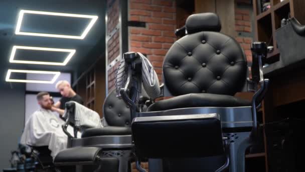 Fodrász vágja az ügyfelek haját egy elegáns fodrászatban — Stock videók