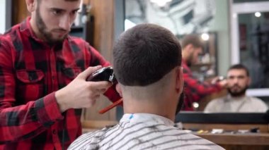 Genç kuaför ve müşteri bir ayakkabı güzellik salonunda saç kesimi sırasında. Ayna görünümü